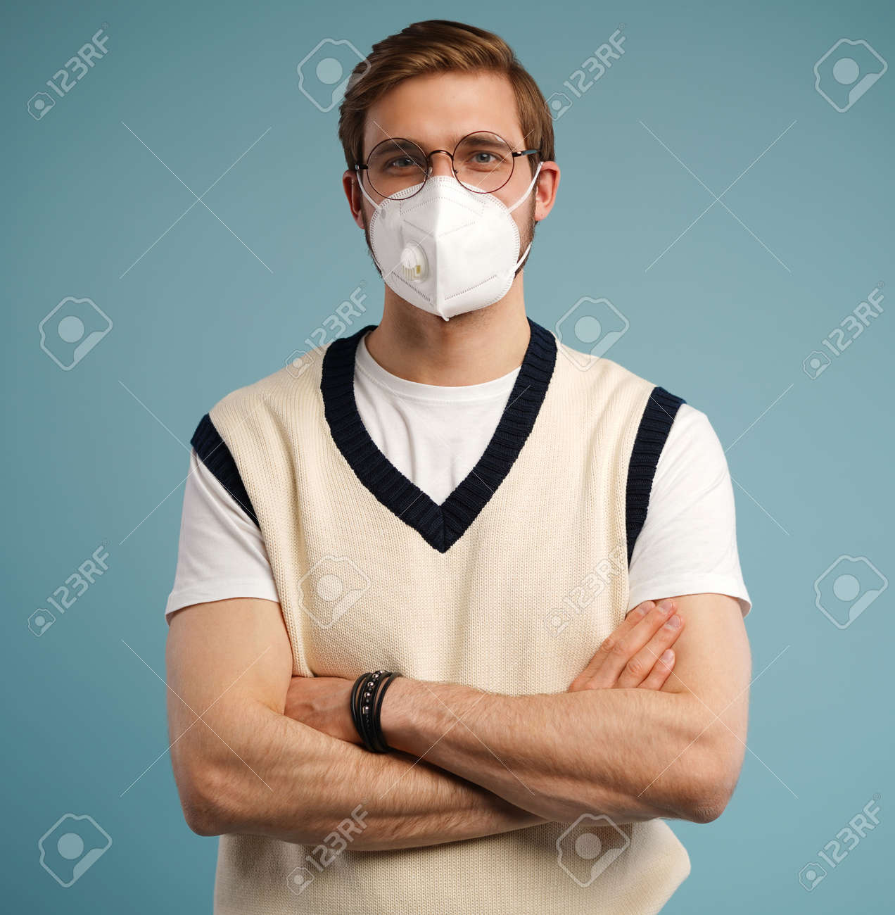 Portrait of handsome young man with surgical medical mask in casual style shirt standing, looking at camera with smile - 171597156 Portrait of handsome young man with surgical medical mask in casual style shirt standing, looking at camera with smile - 171597156