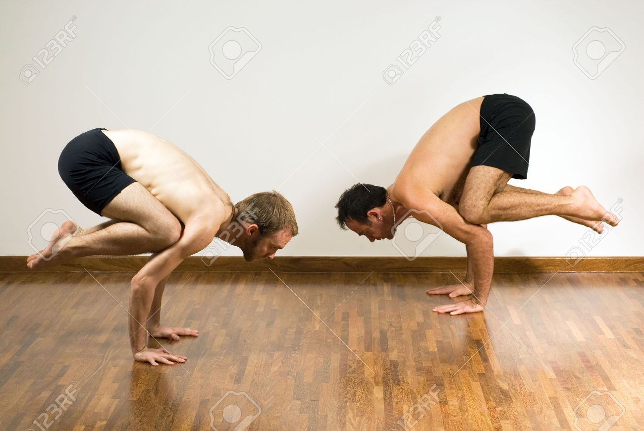 バランシング ポーズで二人の男 彼らは空気中の自分の足で手にうずくまっています 水平方向にフレームの写真 の写真素材 画像素材 Image