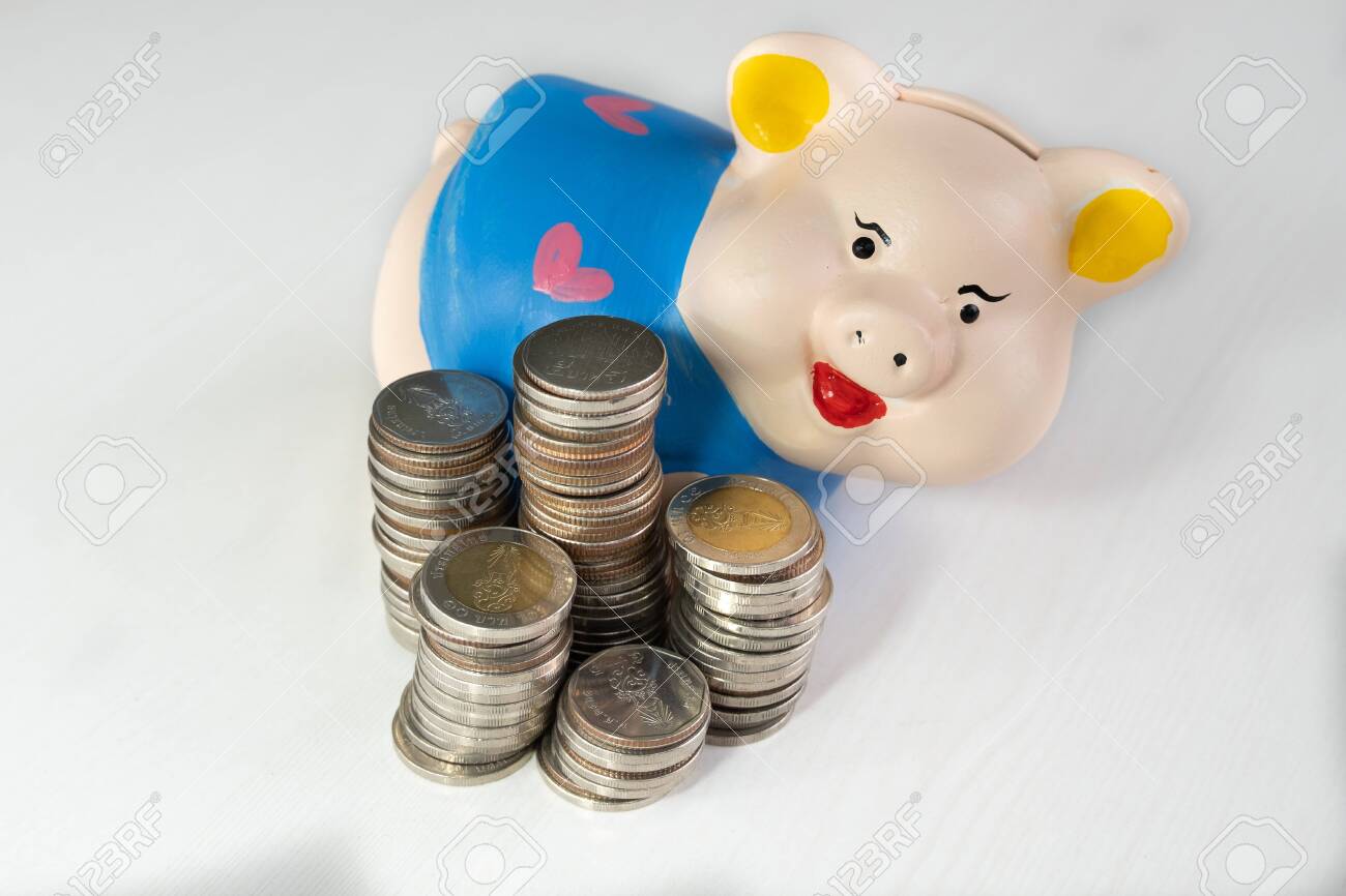 saving money with Blue piggy bank and coins pile. - 128316547 saving money with Blue piggy bank and coins pile. - 128316547