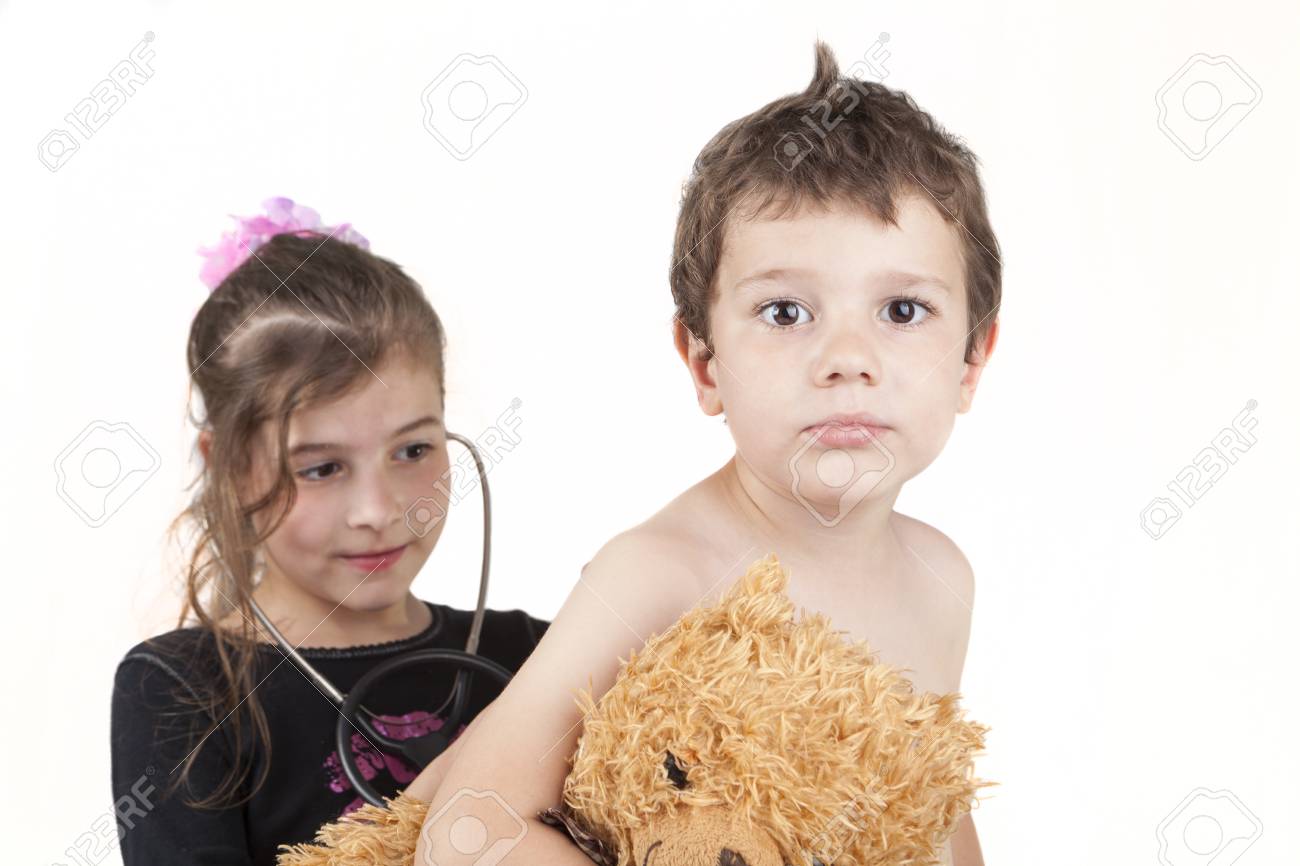 children playing doctor hoding a teddy bear isolated on white children play doctor