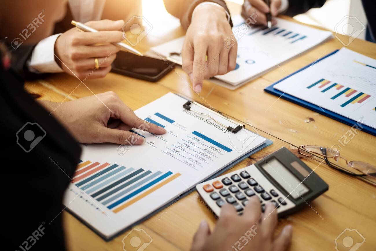 Business team professionals working analyzing data with financial report in the office. Accounting concept. - 120507027 Business team professionals working analyzing data with financial report in the office. Accounting concept. - 120507027