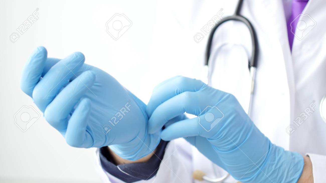 Medica doctor puting on blue latex gloves, closeup - 116534088 Medica doctor puting on blue latex gloves, closeup - 116534088