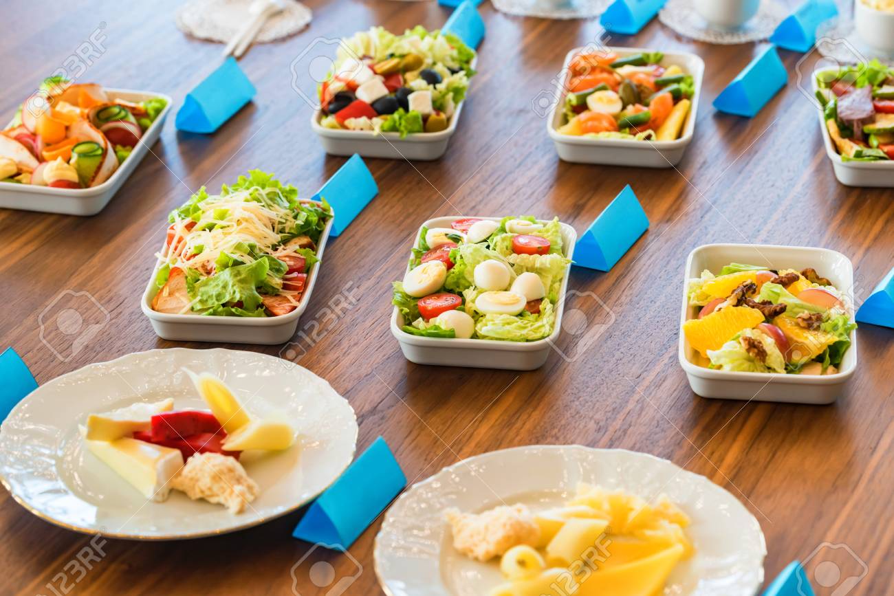 variety to the presentation of food Variety of cheese on wooden background. Female hand adds a slice.