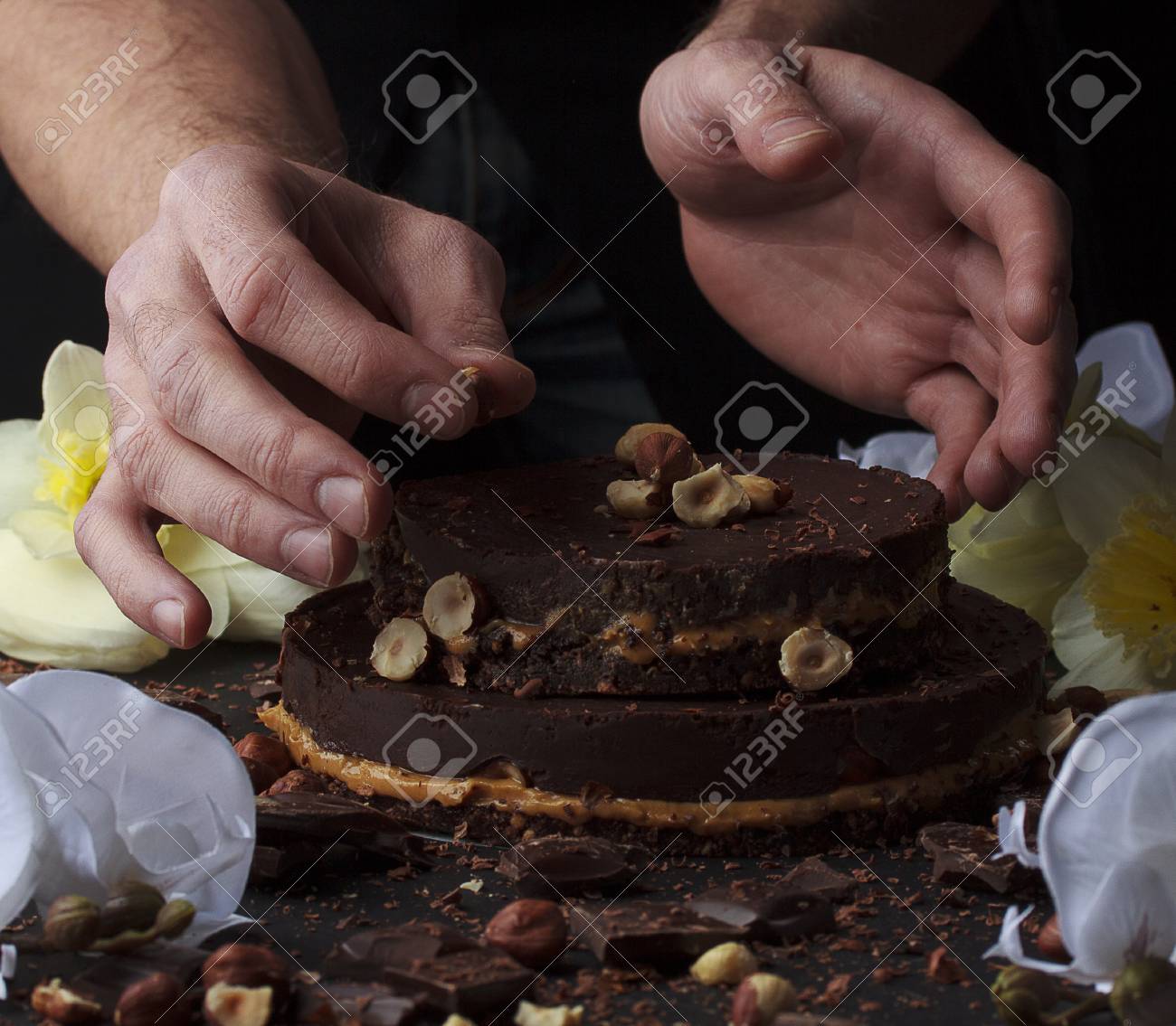 シェフは ナッツと小さなチョコレート ケーキを飾っています の写真素材 画像素材 Image シェフは ナッツと小さなチョコレート ケーキを飾っています の写真素材 画像素材 Image