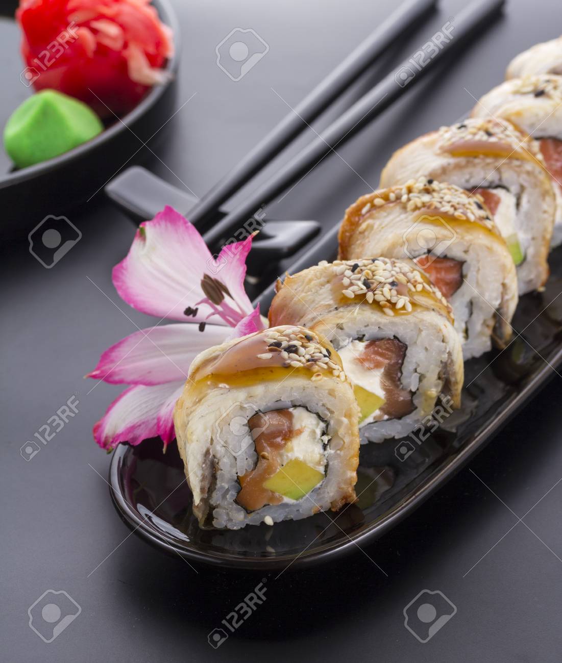 Eel Sushi Roll On A Black Plate With Flower Decoration Stock Photo Eel Sushi Roll On A Black Plate With Flower Decoration Stock Photo 53779622