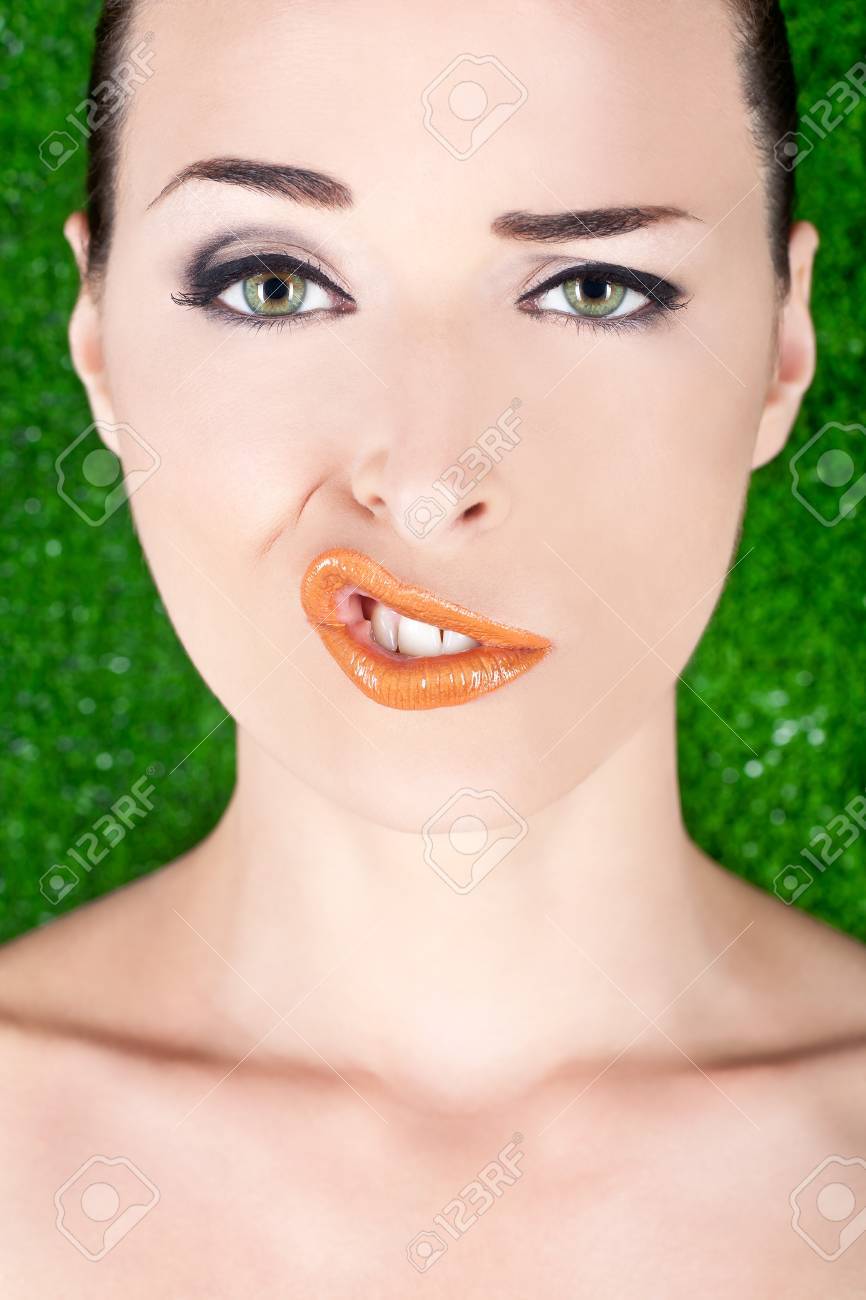 クローズ アップ ファッションの肖像女性グリーン上で分離されて変な顔を引っ張る の写真素材 画像素材 Image