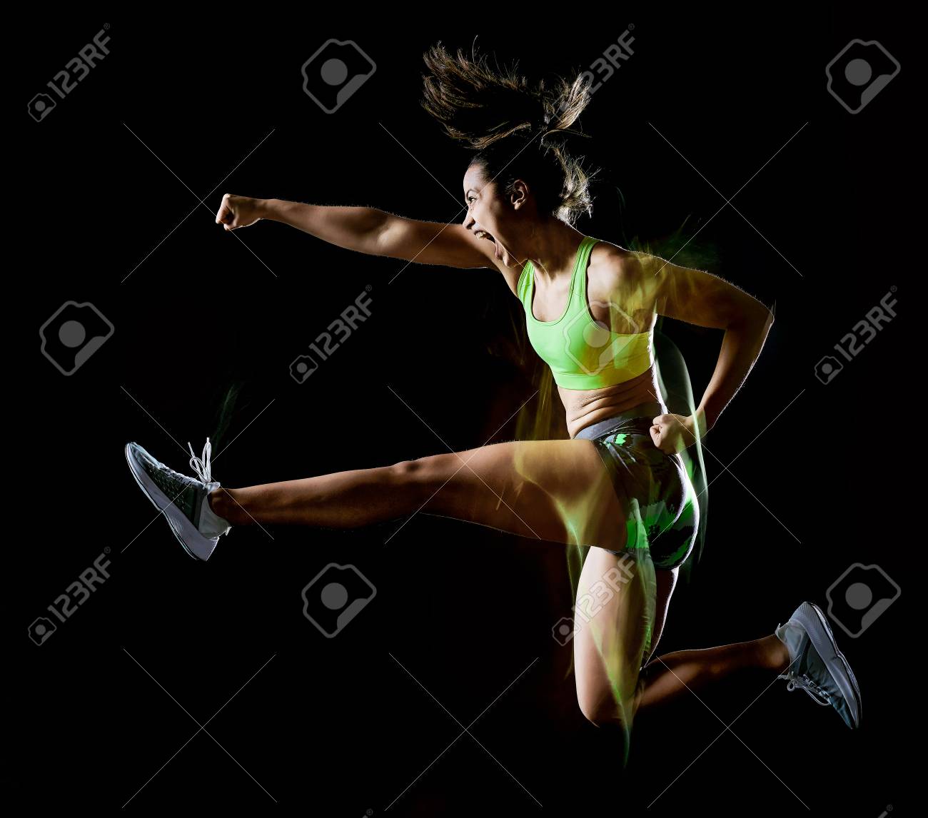 one mixed race woman exercising fitness exercises isolated on black background with lightpainting effect - 120854649 one mixed race woman exercising fitness exercises isolated on black background with lightpainting effect - 120854649