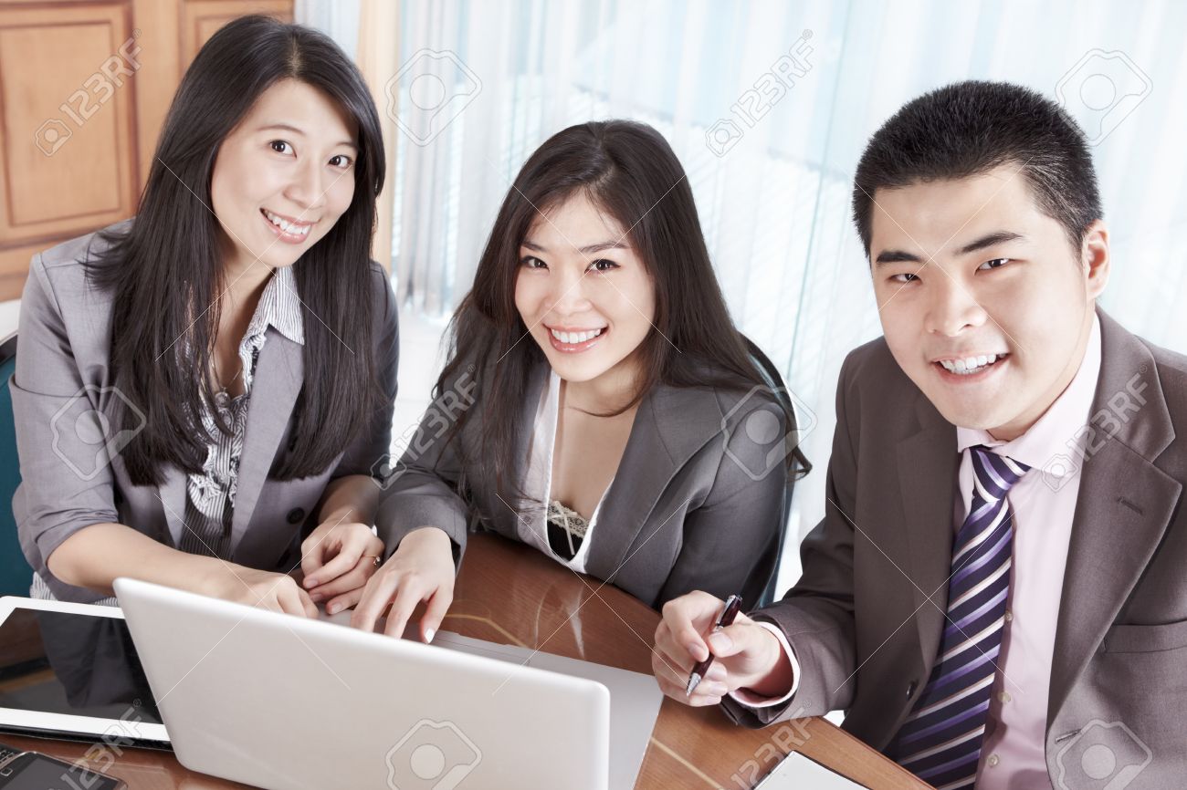 group of chinese business people smiling to camera in the office