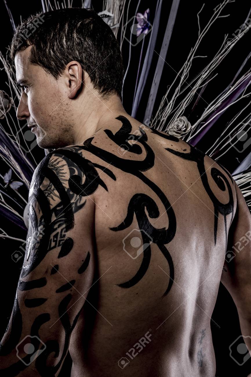 1 つ 昔ながらの野生の服の部族の若い魅力的なレトロなモデル タトゥー ネイティブの野蛮な男 の写真素材 画像素材 Image
