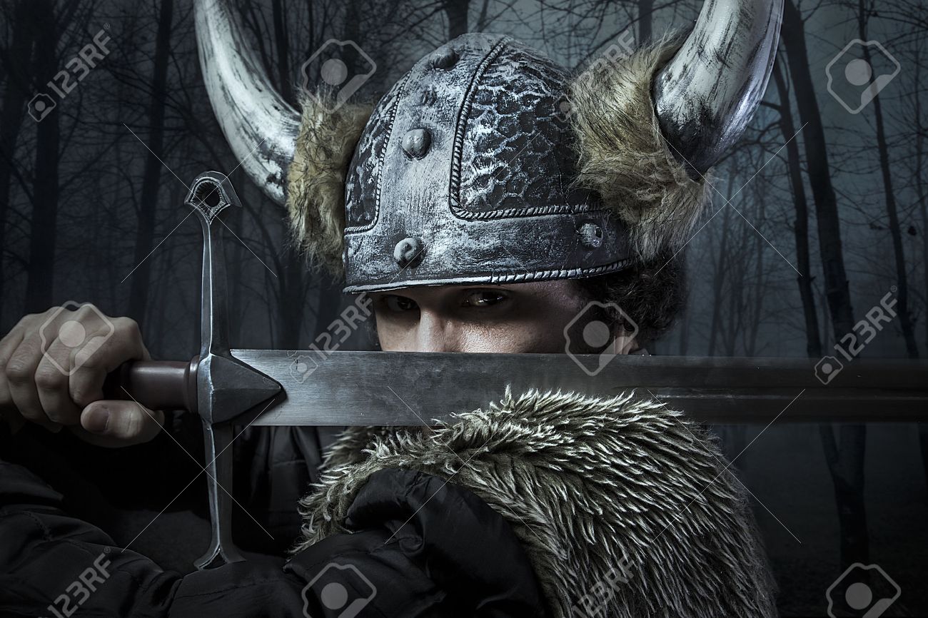 Defense, Viking warrior, male dressed in Barbarian style with sword, bearded - 26334346 Defense, Viking warrior, male dressed in Barbarian style with sword, bearded - 26334346