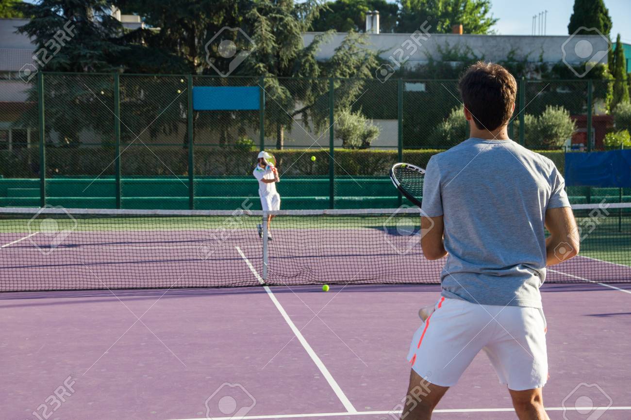 El Jugador Profesional De Tenis Que Juega El Juego En La Pista De Tenis. Él Está De Espaldas A La Cámara Y Tener La Raqueta En Su Mano Derecha. Fotos, Retratos, Imágenes