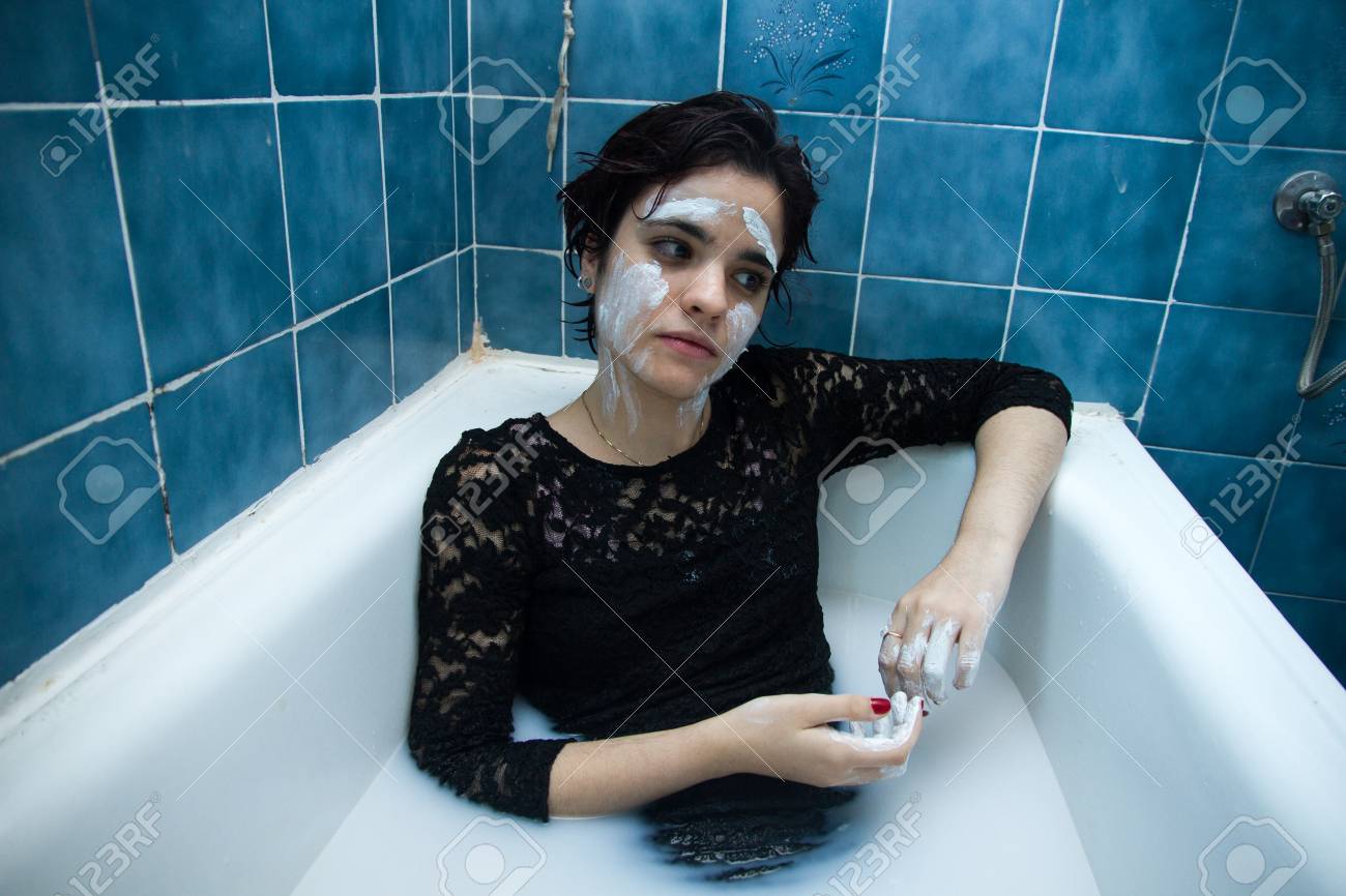 Madchen Mit Weissem Gesicht Malen Mit Kurzen Haaren Und Braunen Augen In Einer Badewanne Voller Wasser Und Milch Baden Sie Geniesst Das Baden In Heissem Wasser Sie Spielt Und Geniessen Malerei Lizenzfreie