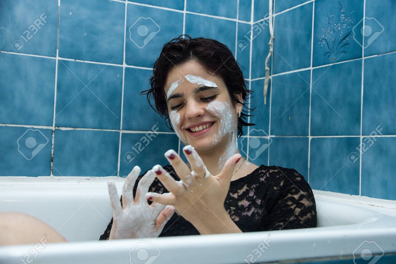 Madchen Mit Weissem Gesicht Malen Mit Kurzen Haaren Und Braunen Augen In Einer Badewanne Voller Wasser Und Milch Baden Sie Geniesst Das Baden In Heissem Wasser Sie Spielt Und Geniessen Malerei Lizenzfreie