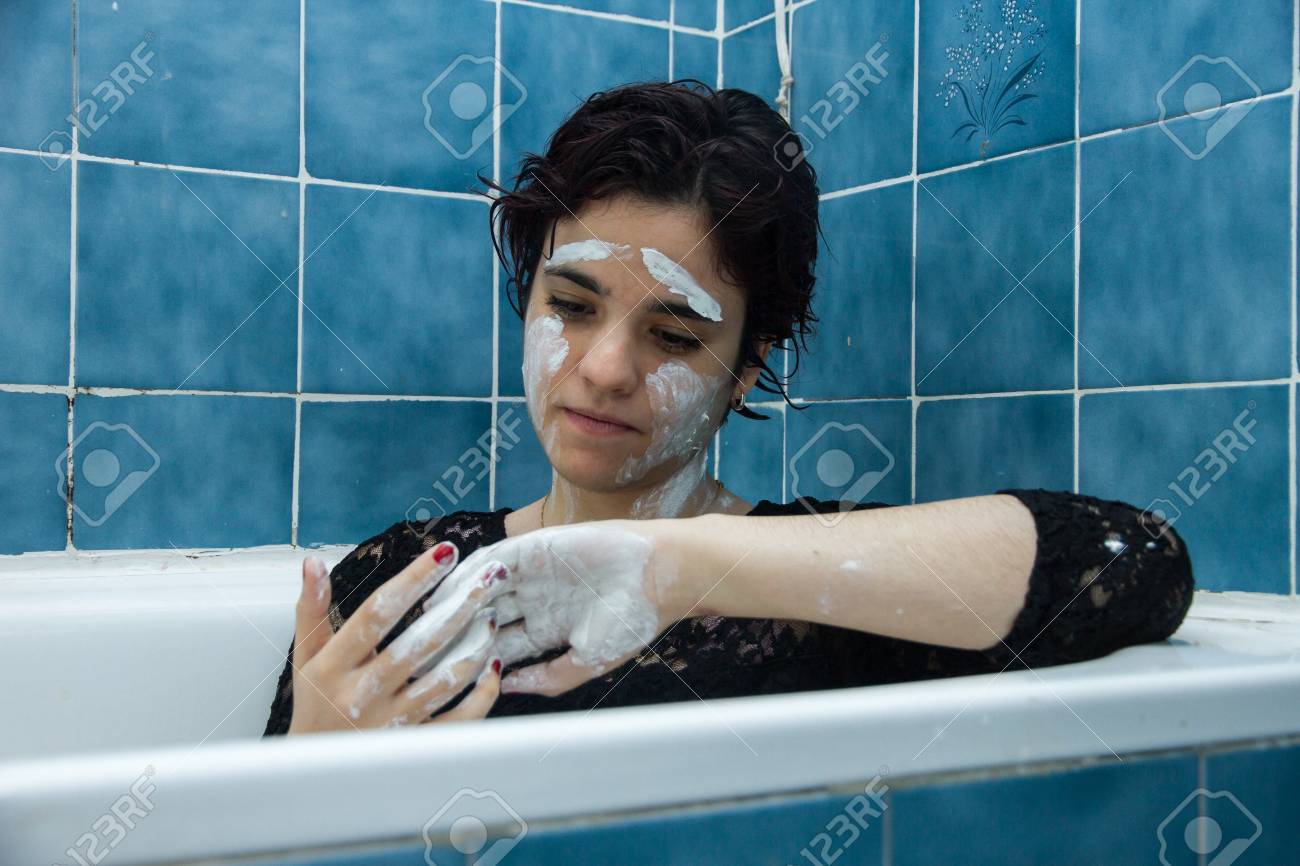 Madchen Mit Weissem Gesicht Malen Mit Kurzen Haaren Und Braunen Augen In Einer Badewanne Voller Wasser Und Milch Baden Sie Geniesst Das Baden In Heissem Wasser Sie Spielt Und Geniessen Malerei Lizenzfreie