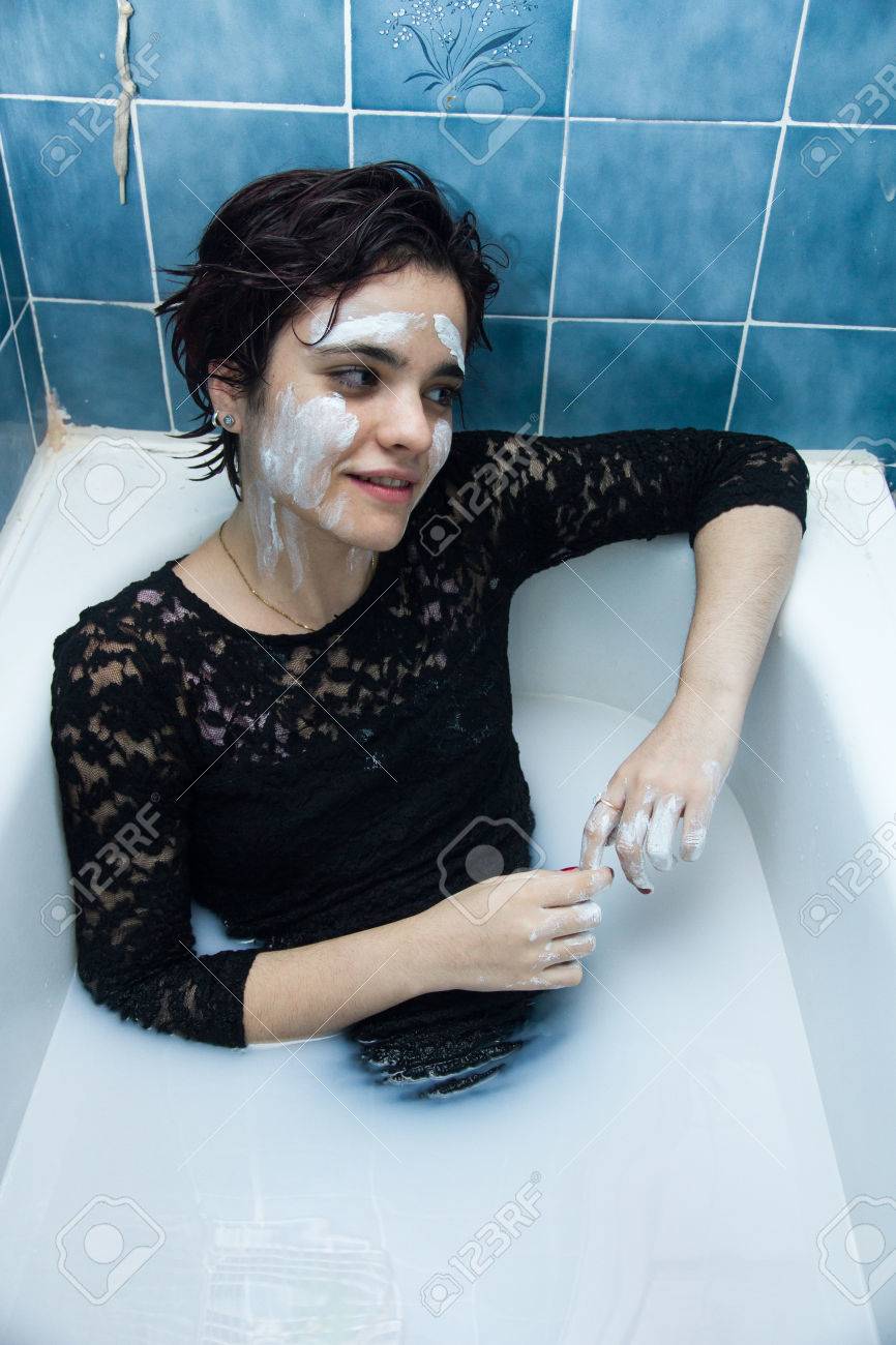 Madchen Mit Weissem Gesicht Malen Mit Kurzen Haaren Und Braunen Augen In Einer Badewanne Voller Wasser Und Milch Baden Sie Geniesst Das Baden In Heissem Wasser Sie Spielt Und Geniessen Malerei Lizenzfreie