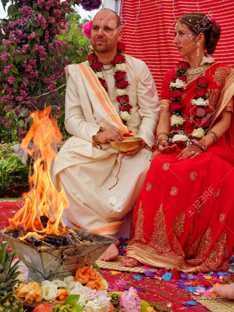 BUSHEY, JUNE 19: Hindu Wedding In The Vedic Tradition, England, UK 2016.  The Bride And Groom Throw Grains Of Rice To The Sacred Fire. Stock Photo,  Picture and Royalty Free Image. Image 62651635., image size:974x1300