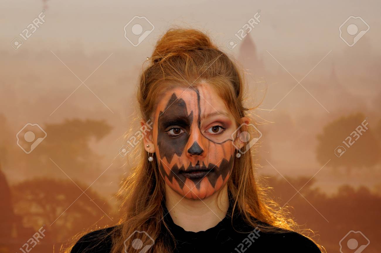 Pretty Girl With Face Painting Of A Pumpkin Stock Photo Picture