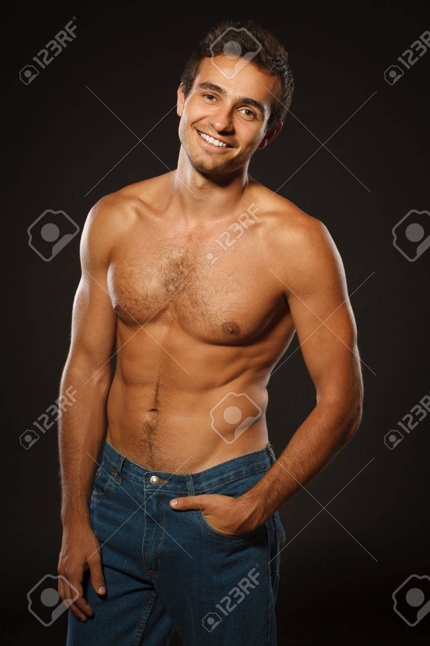 Young Smiling Muscular Male Shirtless Standing Shirtless With Hand In Pocket Over Black Background Stock Photo Picture And Royalty Free Image Image