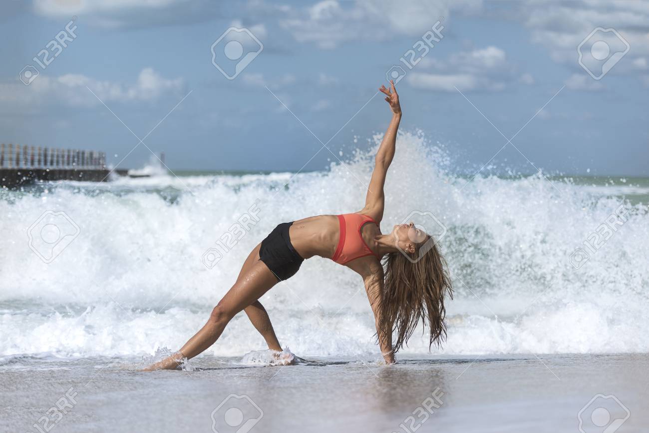 Beautiful Girl Wearing Shorts And Sports Bra In Yoga Pose With