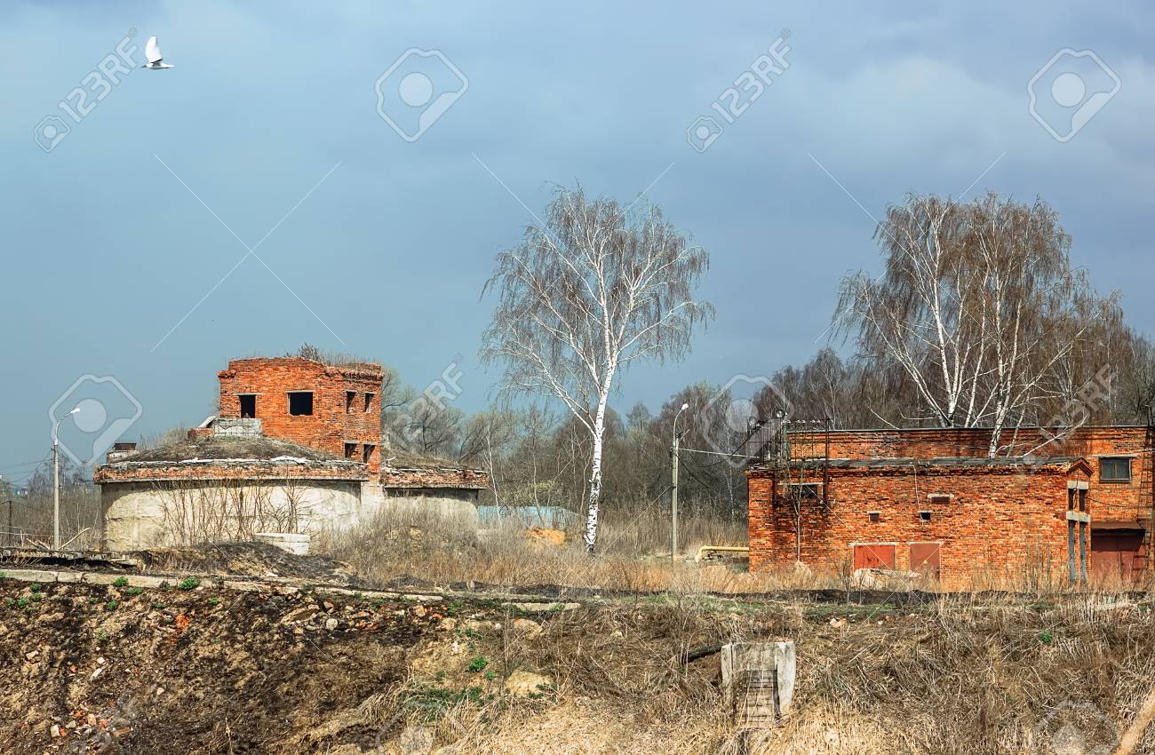 spring landscape with abandoned destroyed technical brick buildings