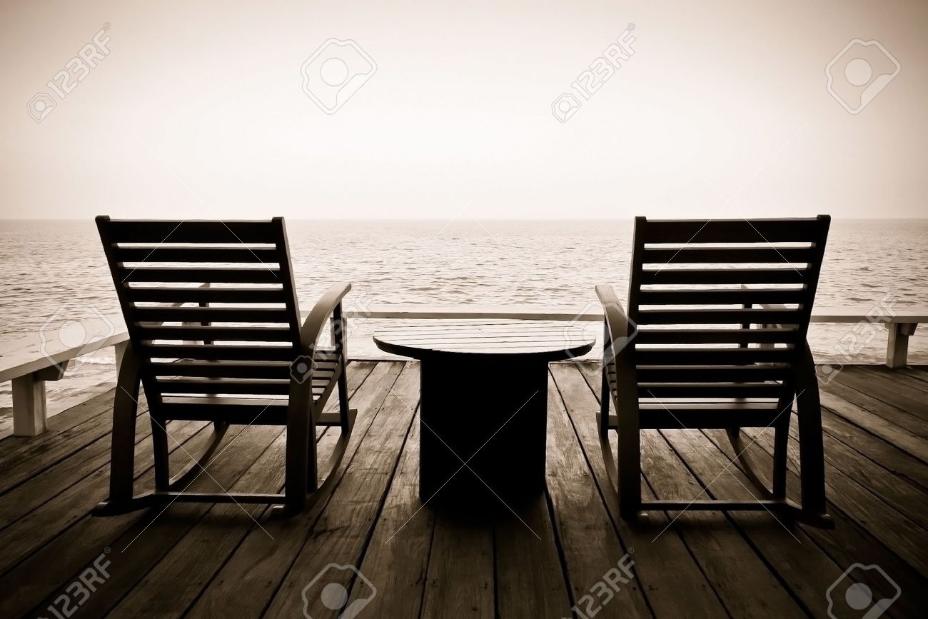Vintage Photo Of Two Wooden Rocking Chairs On The Wooden Porch Vintage photo of two wooden rocking chairs on the wooden porch overlooking the ocean Stock Photo - Vintage Photo Of Two Wooden Rocking Chairs On The Wooden Porch