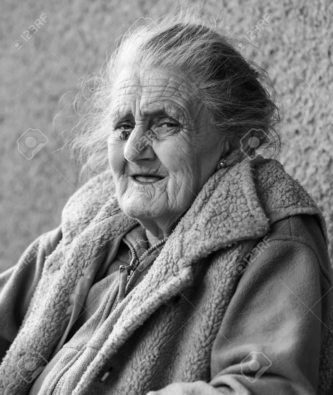 Old age and lifestyle concept black and white portrait of a very old and tired wrinkled woman outdoors very old hoary woman face closeup portrait