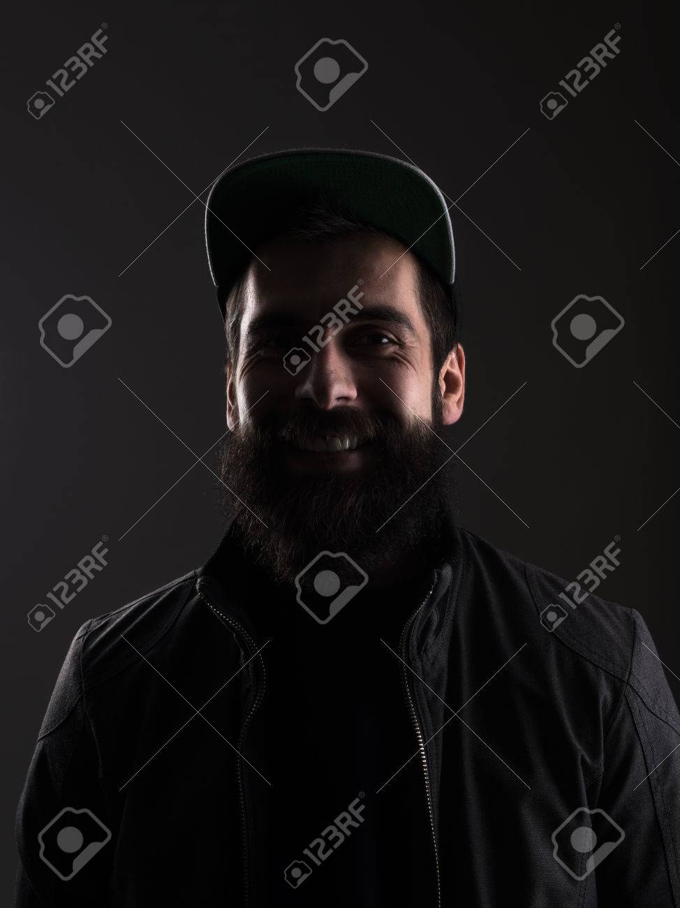 Riendo Hombre De La Barba Joven Con Gorra De Béisbol Mirando Triste hombre que llevaba una gorra de béisbol mirando a