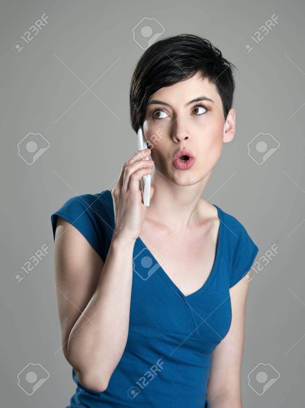 Joven Mujer De Pelo Corto Que Charla En El Telefono Celular Que Mira Lejos Con La Boca Abierta Fotos Retratos Imagenes Y Fotografia De Archivo Libres De Derecho Image 59139325