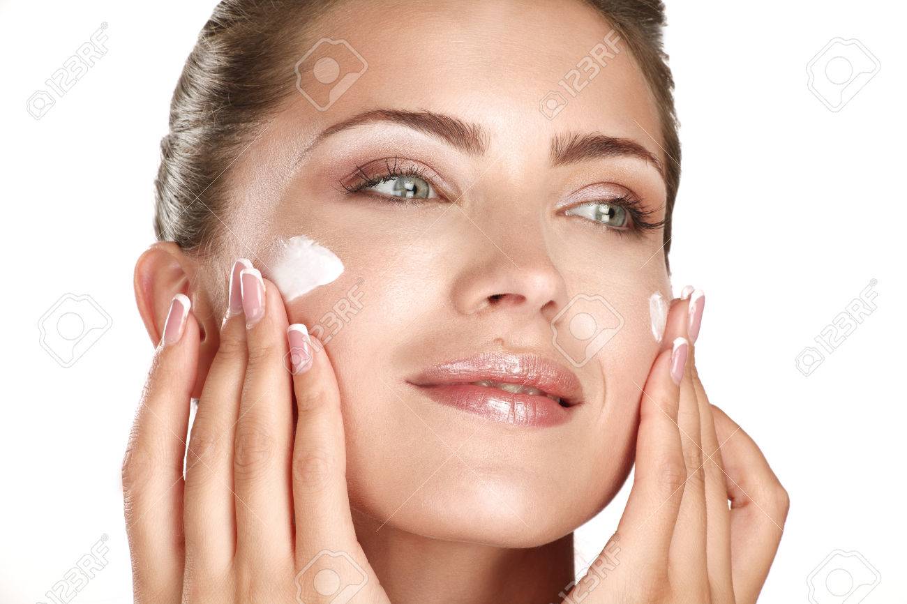 beautiful model applying cosmetic cream treatmen on her face on white - 22642312 beautiful model applying cosmetic cream treatmen on her face on white - 22642312