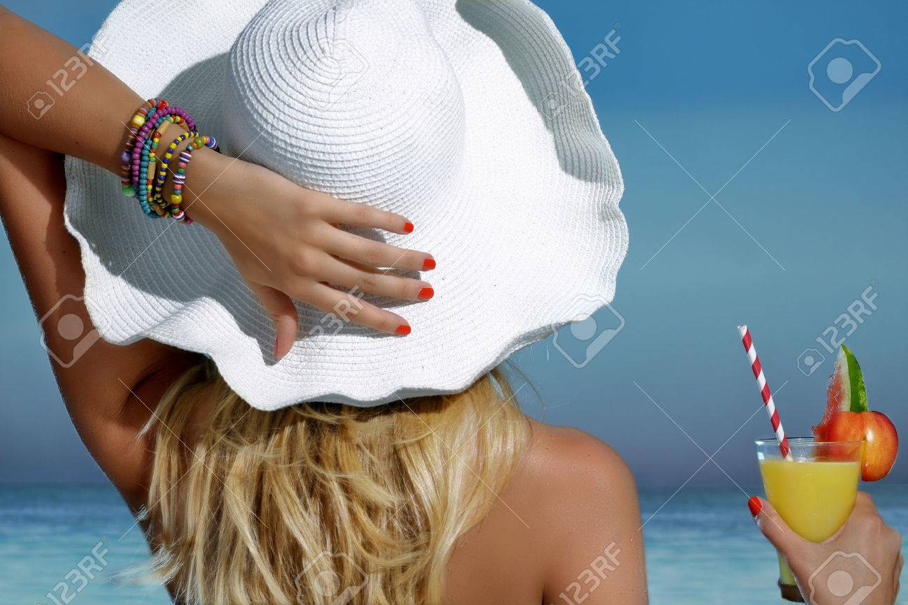 Elegant beautiful woman refreshing on the beach looking the sea - 46075805 Elegant beautiful woman refreshing on the beach looking the sea - 46075805
