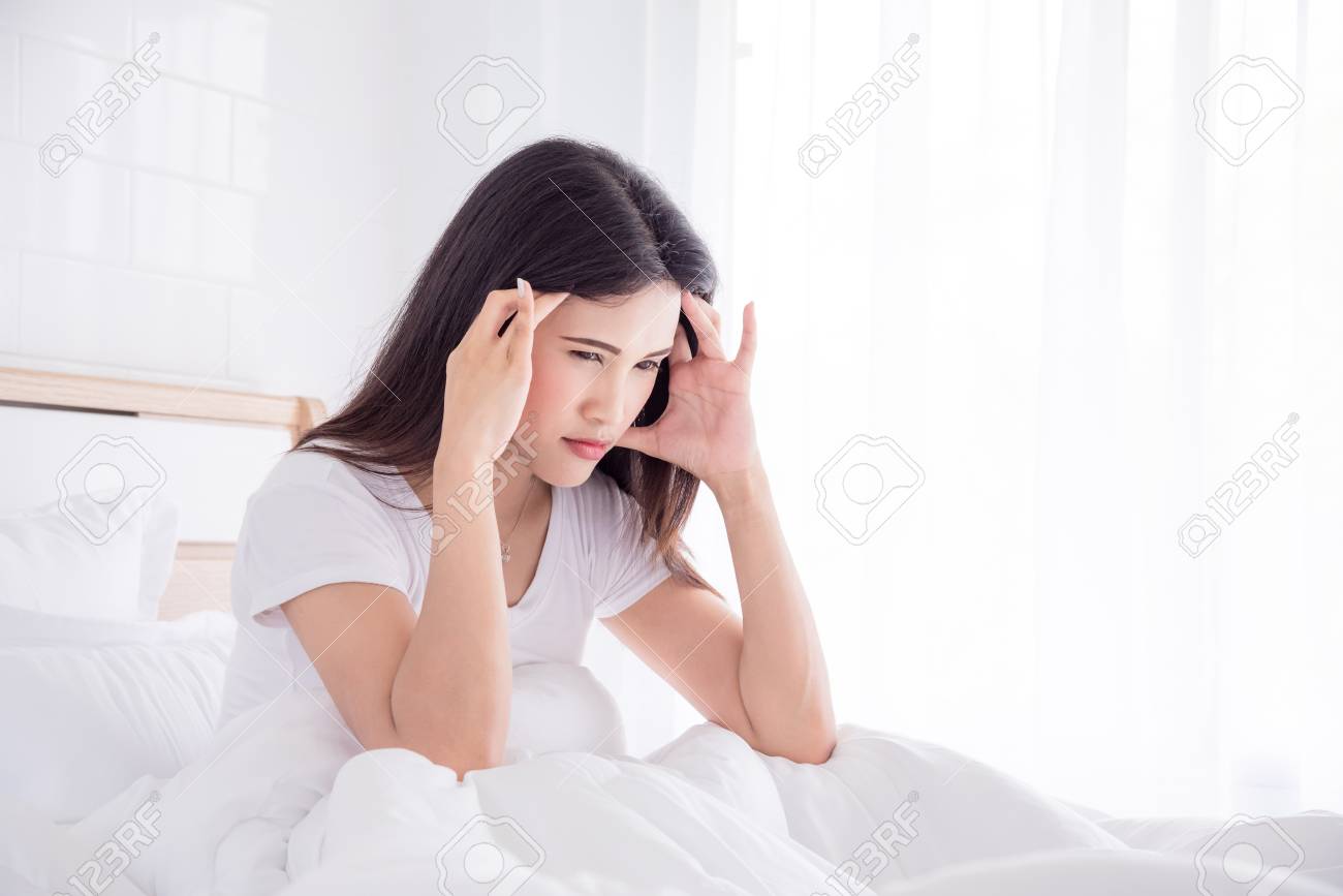 Headache woman sitting on bed - 83225630 Headache woman sitting on bed - 83225630