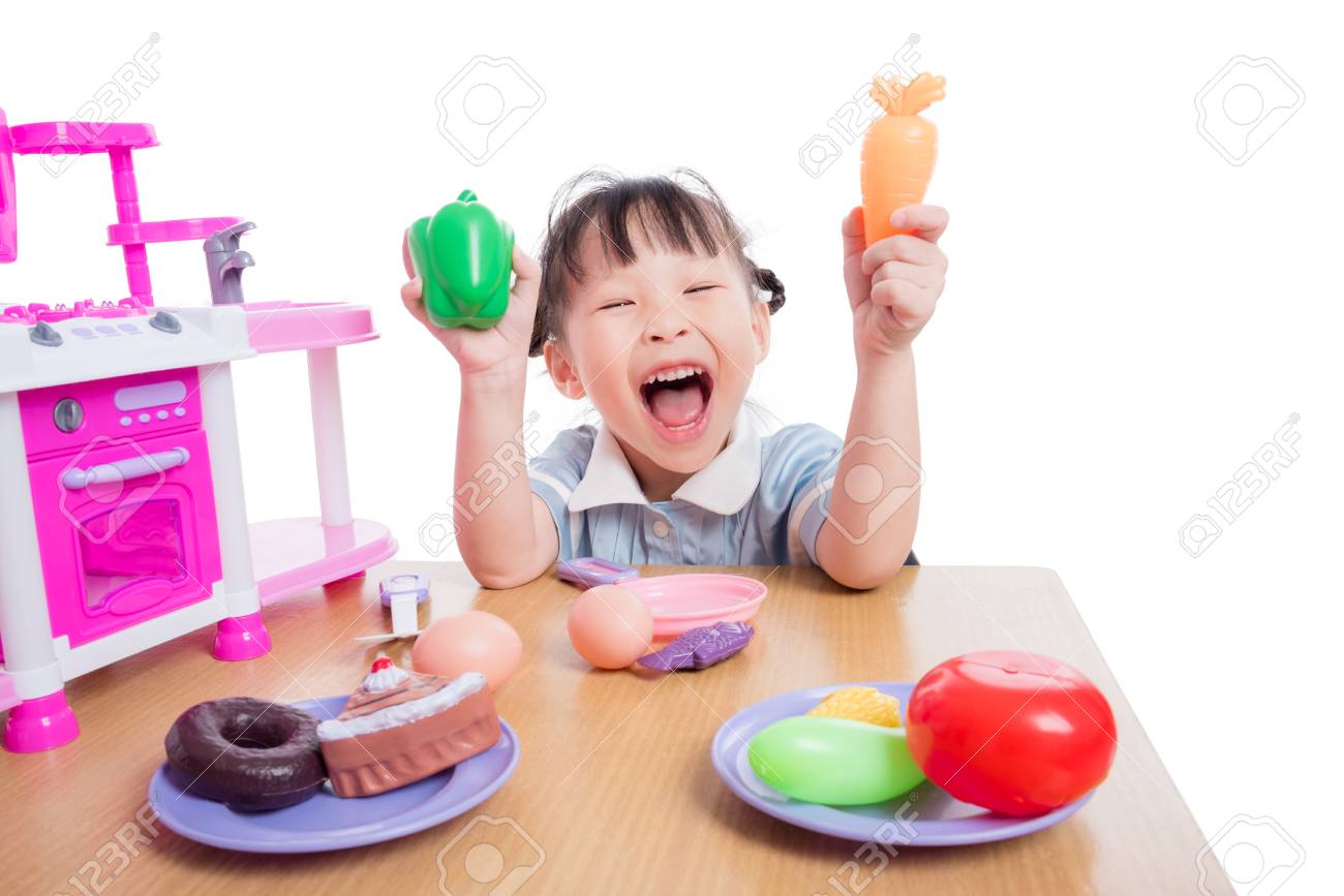 Girl playing kitchen toy on table - 95053279 Girl playing kitchen toy on table - 95053279