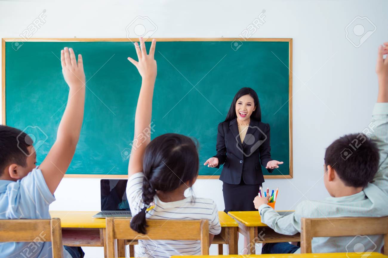 Beautiful asian teacher teaching students in classroom - 102594167 Beautiful asian teacher teaching students in classroom - 102594167