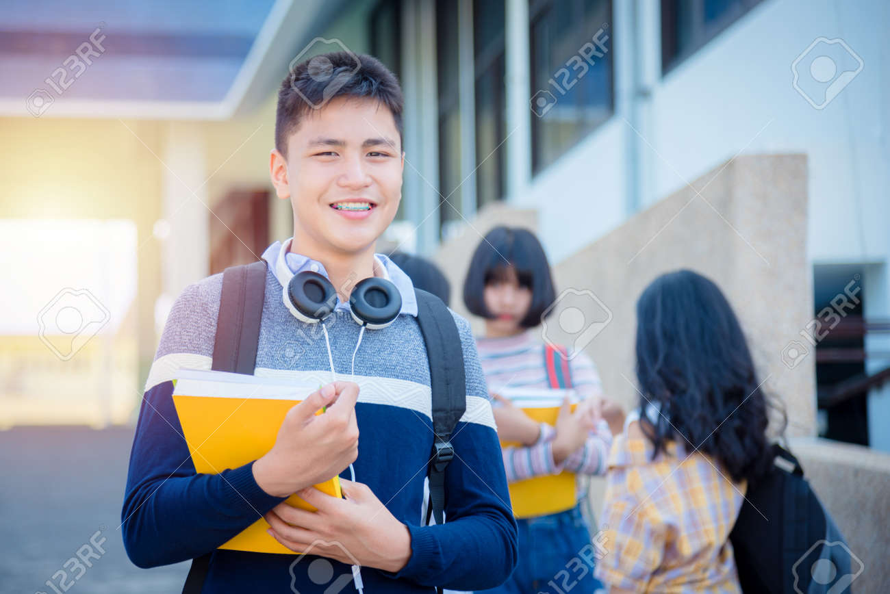 Jovem Asiático Adolescente Do Sexo Masculino Em Pé E Sorri Na Escola. Foto  Royalty Free, Gravuras, Imagens e Banco de fotografias. Image 157772674