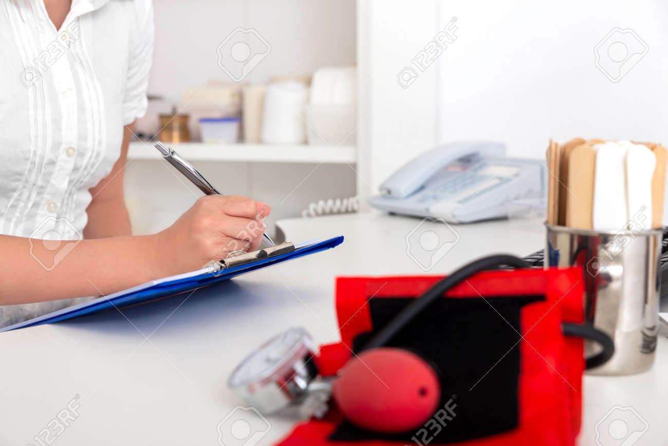 female doctor, nurse or secretary is doing some paperwork in the medical office - 170382649 female doctor, nurse or secretary is doing some paperwork in the medical office - 170382649