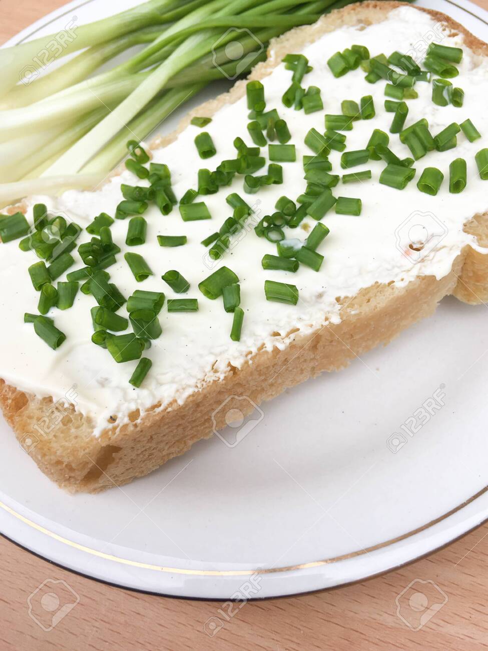 sandwich with bread with sour cream and onions on a plate on a wooden table. healthy breakfast for every day - 148012956 sandwich with bread with sour cream and onions on a plate on a wooden table. healthy breakfast for every day - 148012956