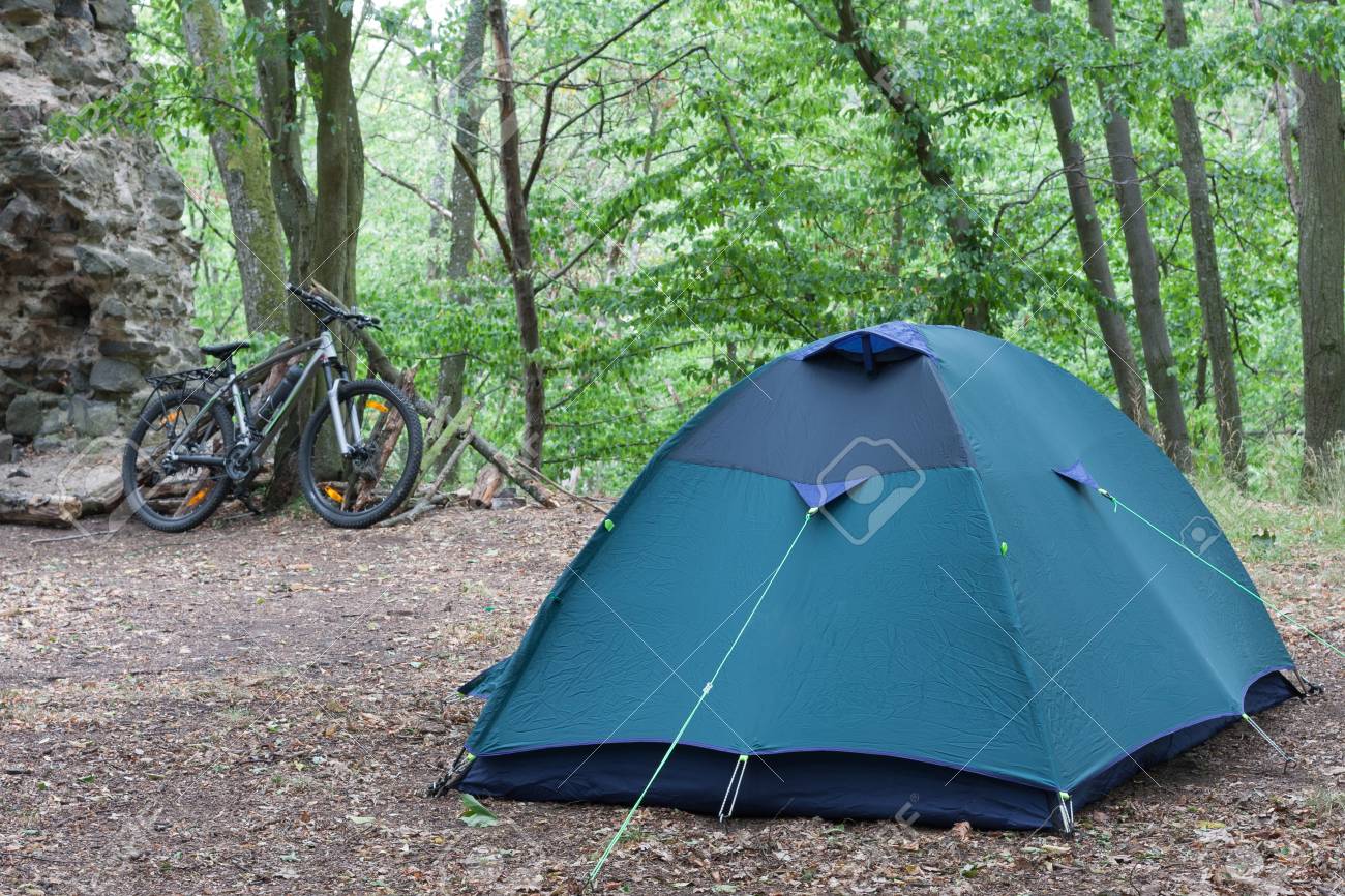 Tenda da campeggio turistica nei boschi, la bici del viaggiatore è sullo sfondo. Tenda da campeggio turistica nei boschi, la bici del viaggiatore è sullo sfondo.