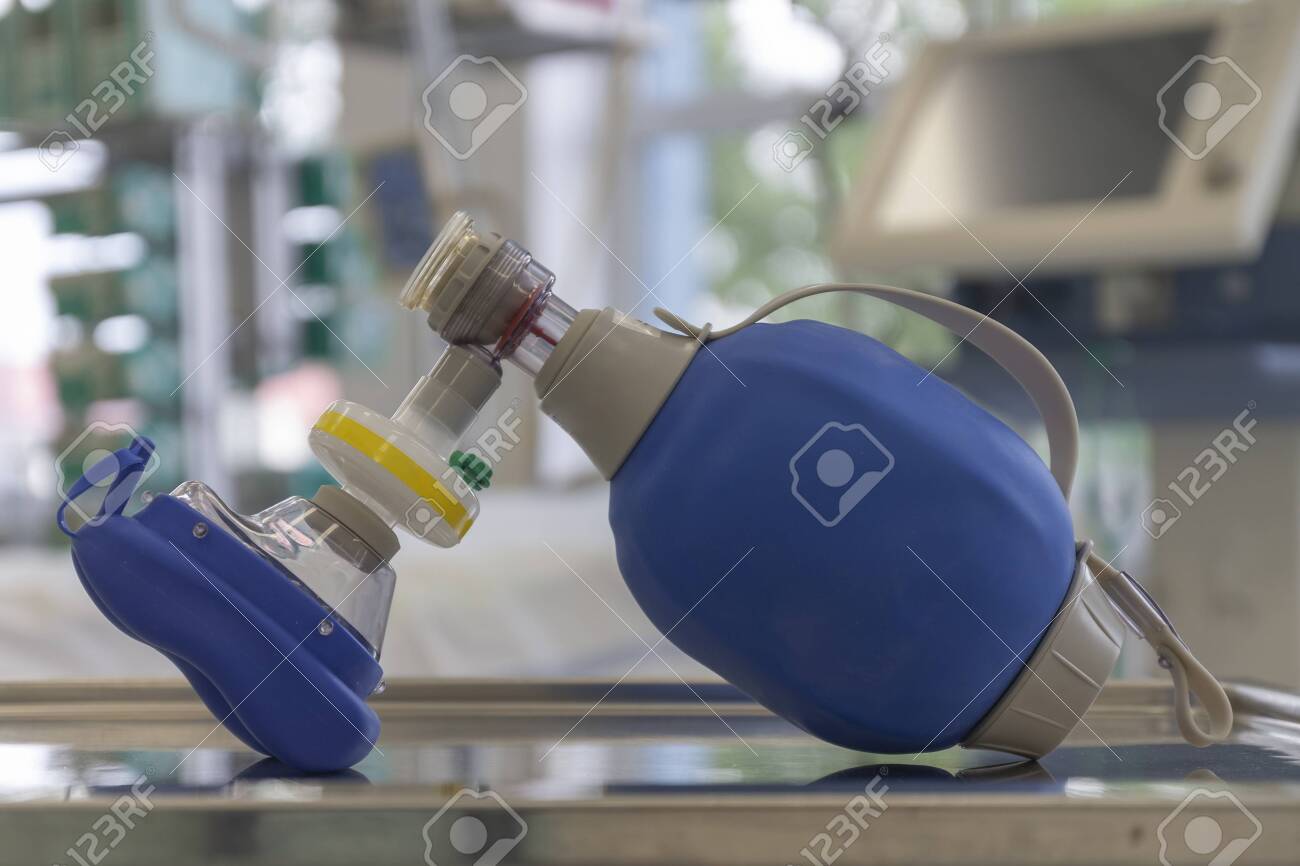 Breathing bag with filter and mask , on background medical ventilator in ICU in hospital, a place where can be treated patients with pneumonia caused by coronavirus covid-19. - 144260096 Breathing bag with filter and mask , on background medical ventilator in ICU in hospital, a place where can be treated patients with pneumonia caused by coronavirus covid-19. - 144260096
