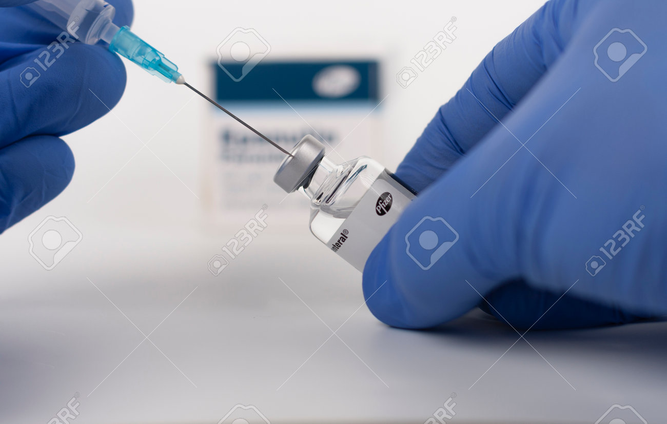 Brnenec, Czech Republic - December 12, 2020: Fingers in gloves, syringe and vial of Epanutin. Epanutin is produced by Pfizer. Pharmaceutical corporation Pfizer also developed a vaccine on Covid-19. - 161915005 Brnenec, Czech Republic - December 12, 2020: Fingers in gloves, syringe and vial of Epanutin. Epanutin is produced by Pfizer. Pharmaceutical corporation Pfizer also developed a vaccine on Covid-19. - 161915005