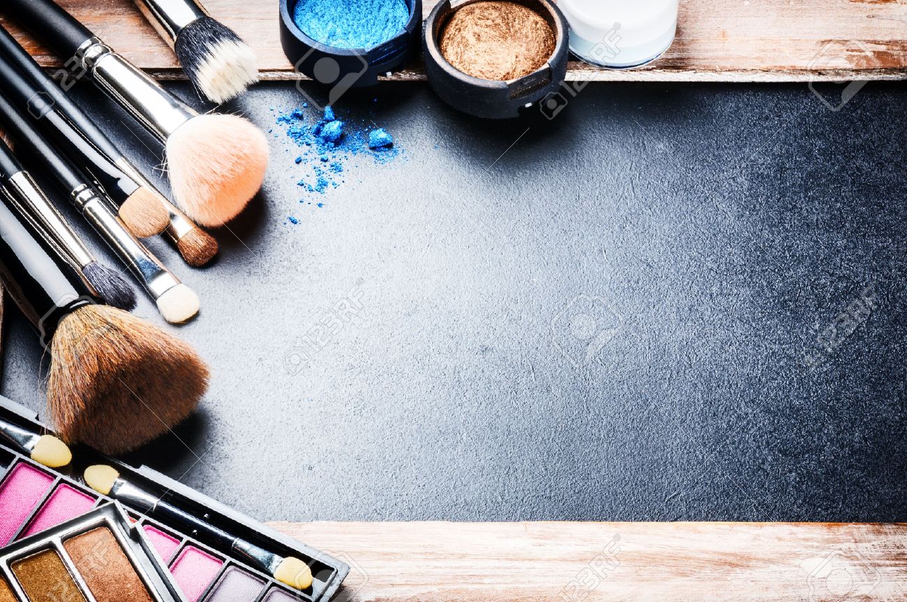 Various makeup products on dark background with copyspace