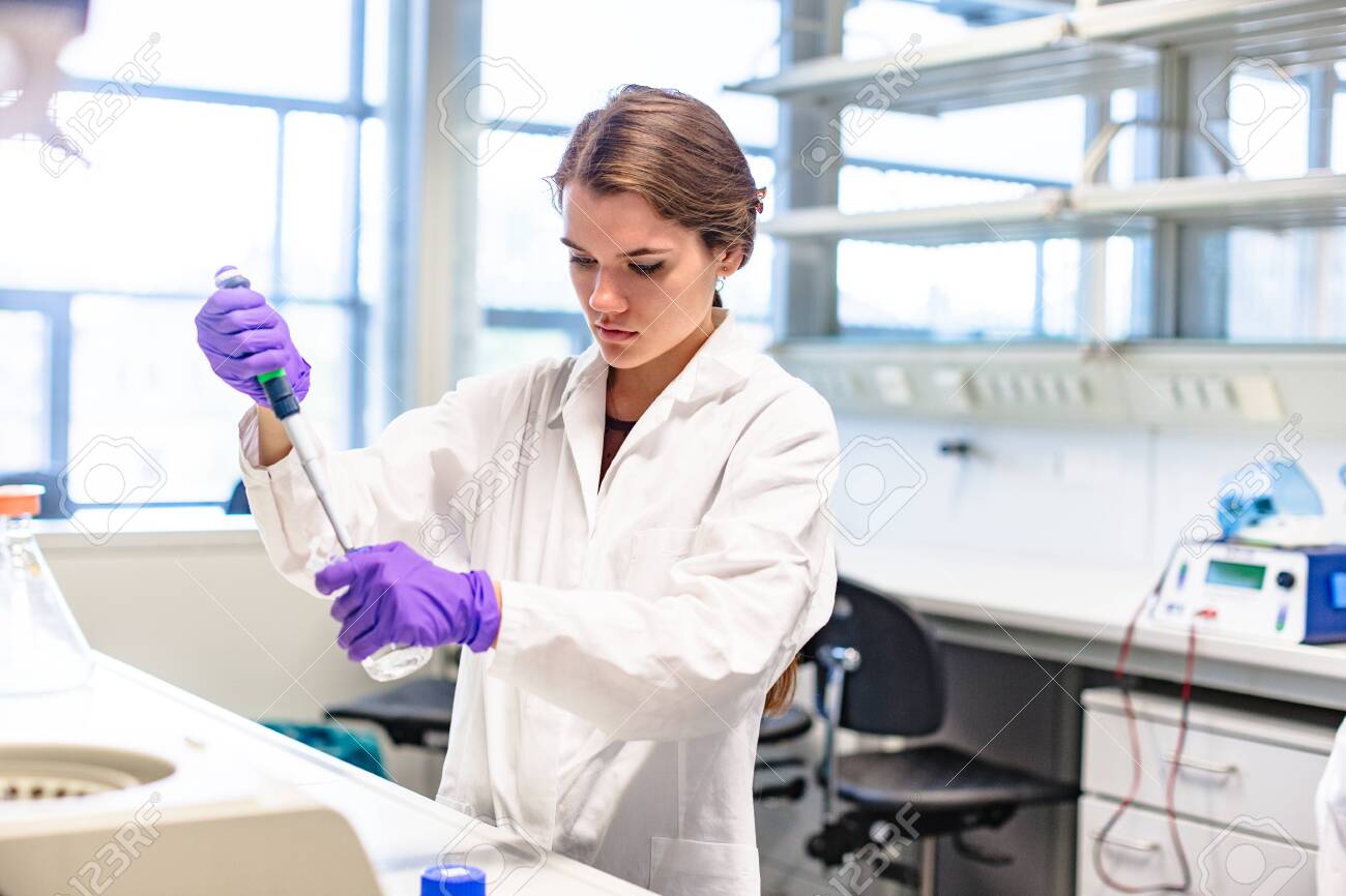 Girl researcher drips test liquid into test tube - 143696311 Girl researcher drips test liquid into test tube - 143696311