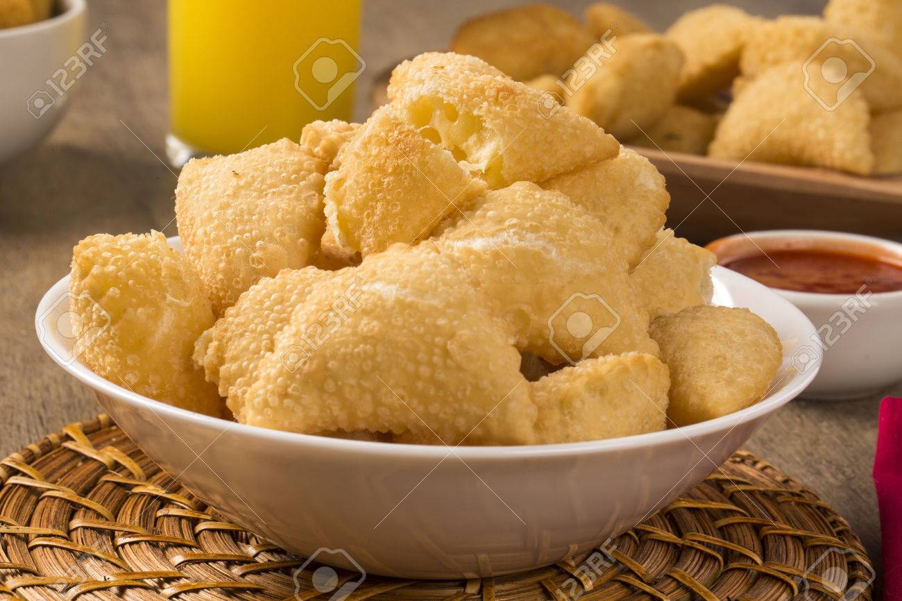 Pastel, a Brazilian snack, with a bar in the background. Cheese pastry on wooden background. - 52613035 Pastel, a Brazilian snack, with a bar in the background. Cheese pastry on wooden background. - 52613035