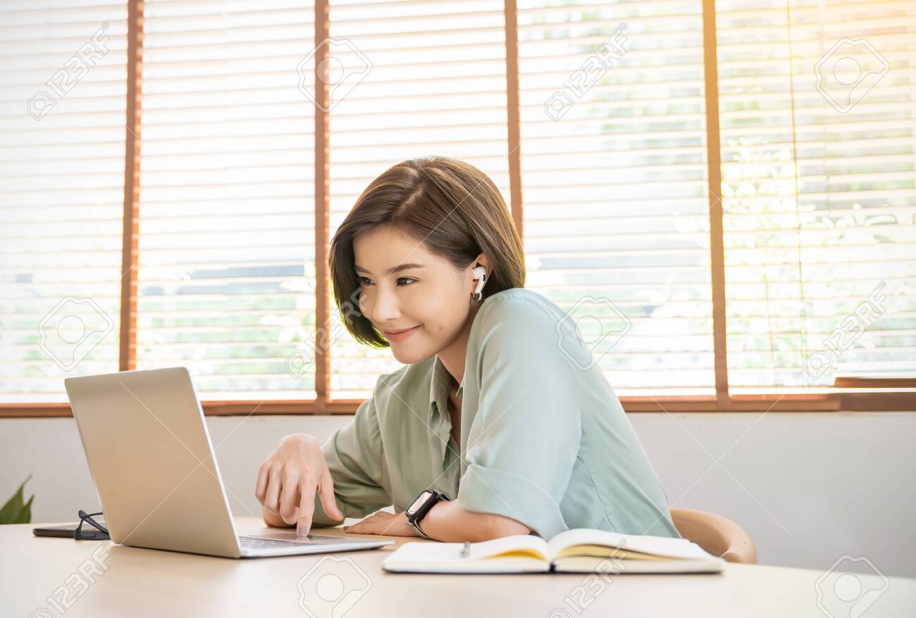 Portrait of happy young asian girl student wear headphone watch webinar conference video call. Young woman listen online course communicate, e-learn language lesson looking at laptop at home. Virtual concept - 156613539 Portrait of happy young asian girl student wear headphone watch webinar conference video call. Young woman listen online course communicate, e-learn language lesson looking at laptop at home. Virtual concept - 156613539