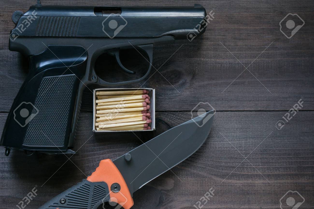 タフな男のためのサバイバル キット 暗い茶色の背景にフォールディング ナイフと黒い銃マッチ箱 トップ角度空中ショット の写真素材 画像素材 Image