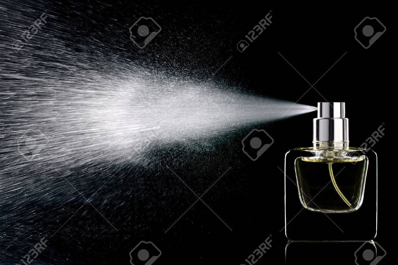 spraying perfume bottle glass on a black background isolated stock