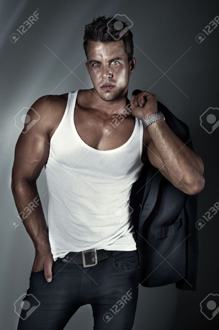 セクシーなファッションはスタジオ カメラ目線でポーズ筋肉のボディとスタイリッシュなジーンズでホット男性モデルの肖像画 の写真素材 画像素材 Image