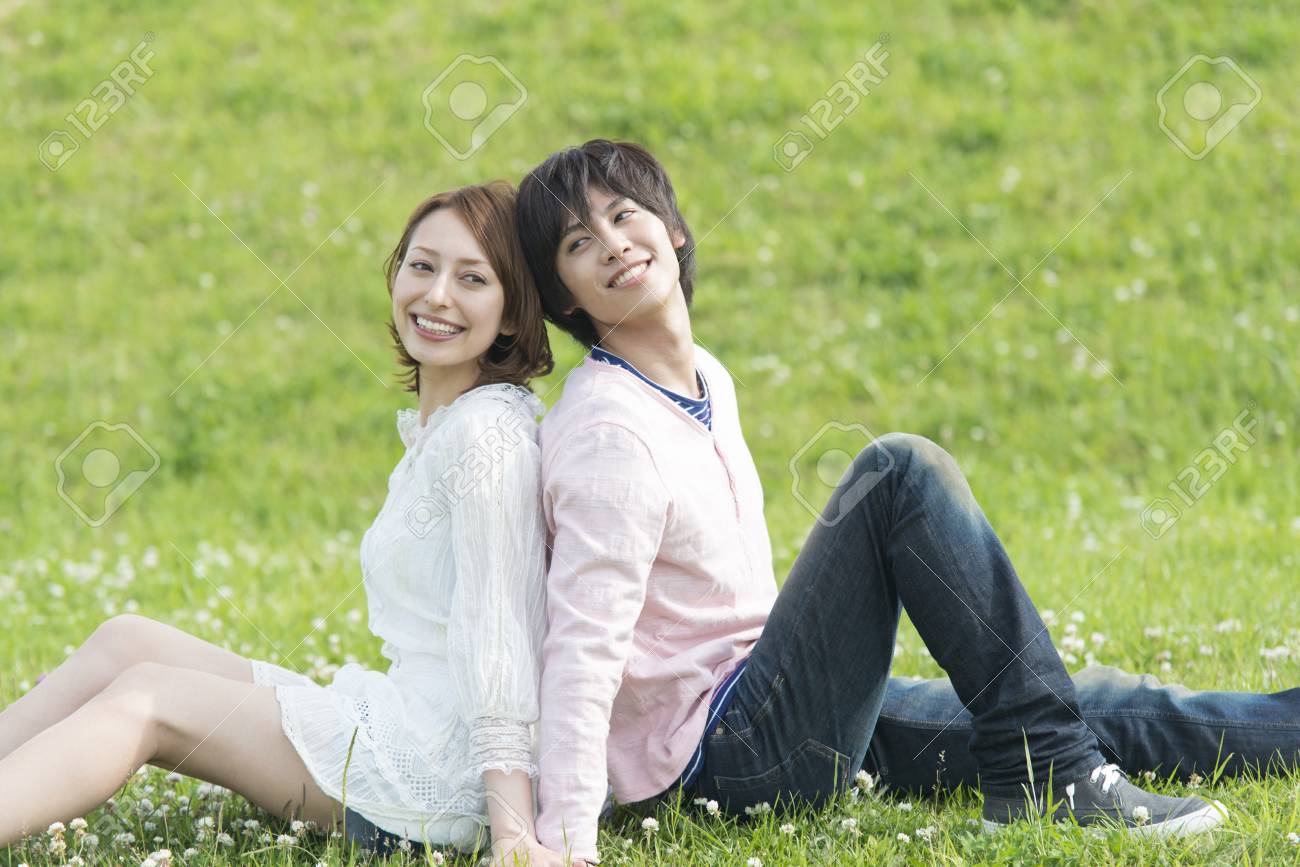 男性と女性は笑顔背中合わせに座っていた の写真素材 画像素材 Image