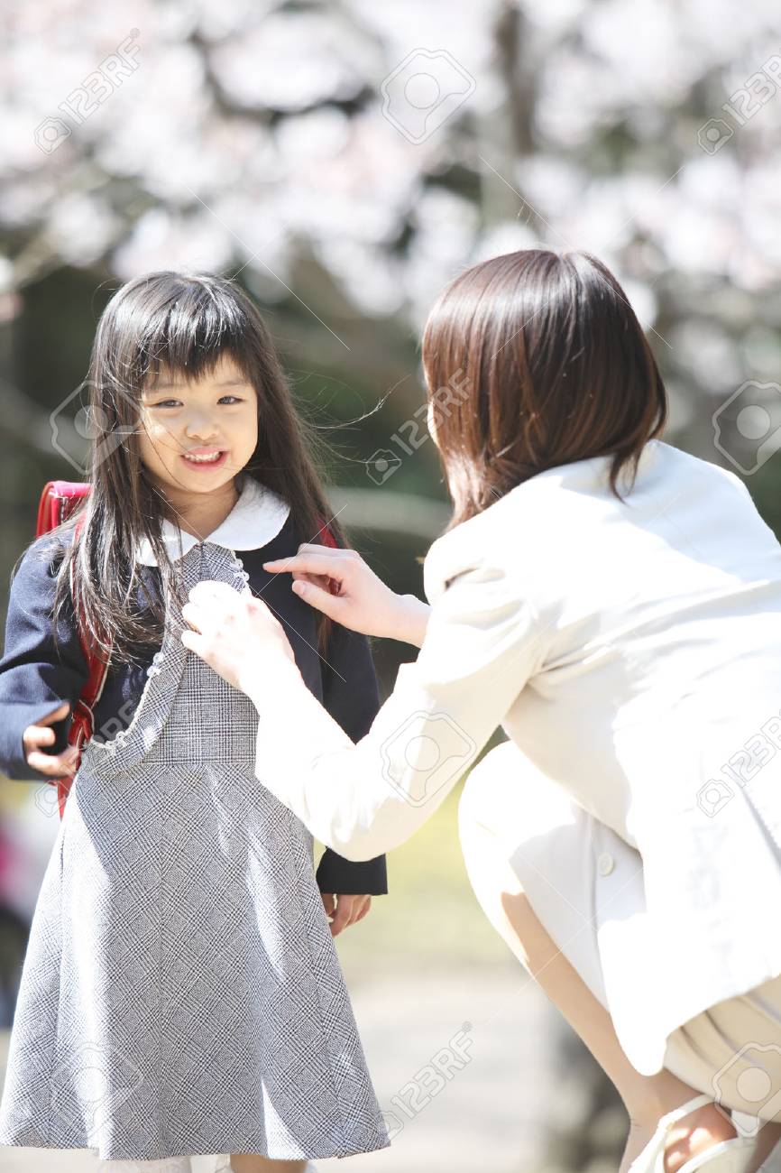 母は小学生の女の子の服を準備します の写真素材 画像素材 Image