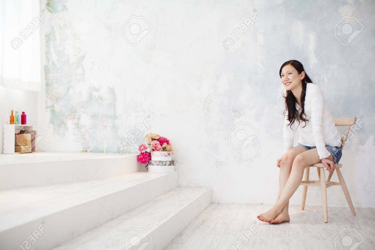 Young Beautiful Girl Posing Nude In Studio, Sitting On Chair Stock Photo