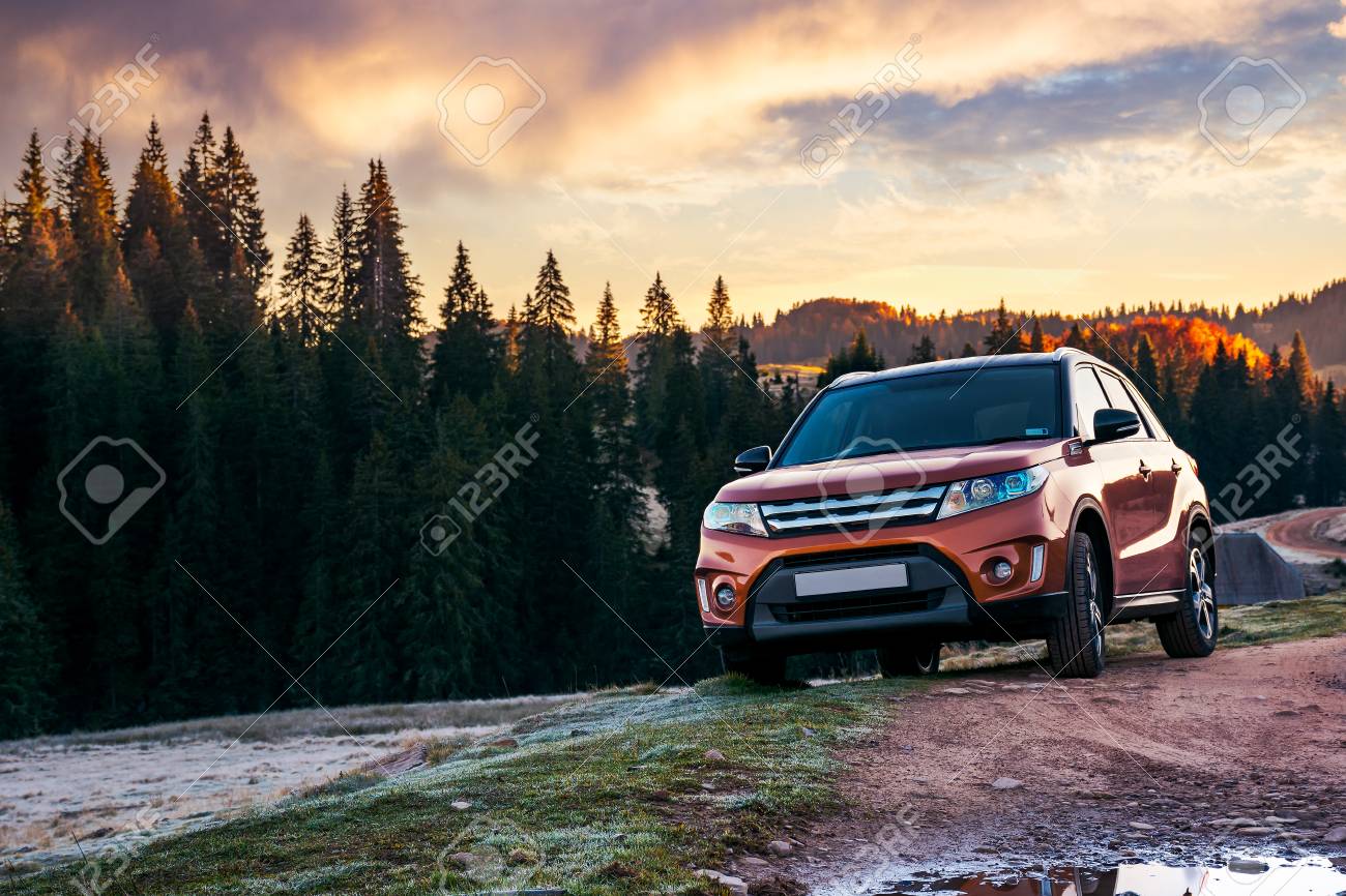 orange 4wd suv parked in mountain at sunrise. beautiful autumn scenery with gravel road through spruce forest. travel Europe by car concept - 108411214 orange 4wd suv parked in mountain at sunrise. beautiful autumn scenery with gravel road through spruce forest. travel Europe by car concept - 108411214